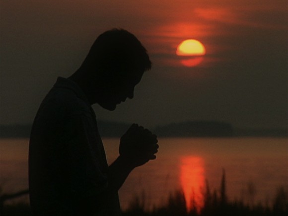 man-praying-alone-silhouette-sunset